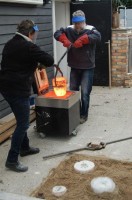 de smeltkroes wordt met en tang in de gietlummel gezet